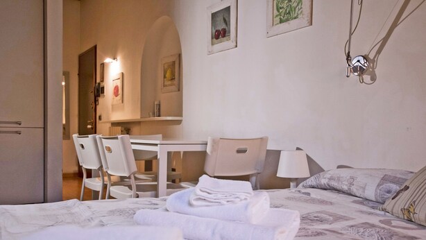 Een hotelkamer met een bed, een bureau, stoelen en een eettafel.