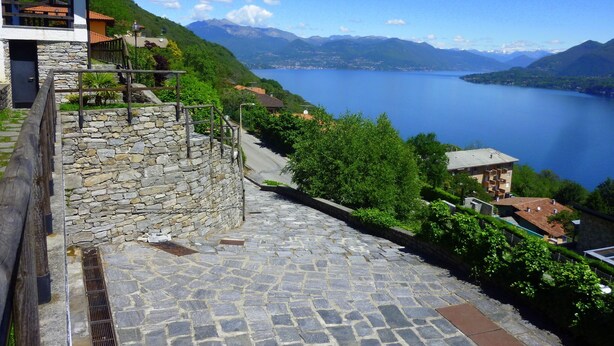 Una escalera de piedra que conduce a un edificio con vistas a un lago y montañas.
