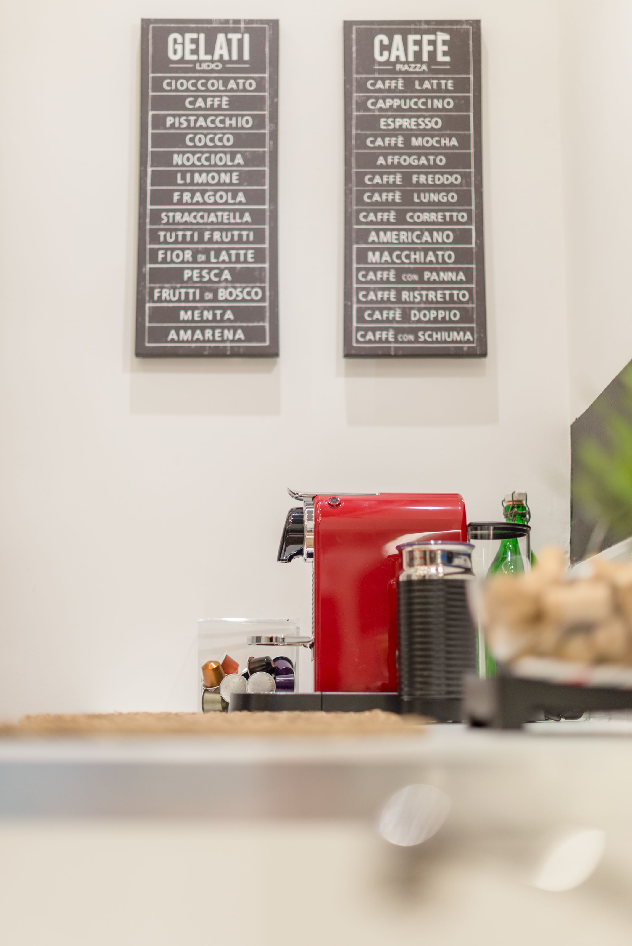 A wall with two signs listing gelati and caffe varieties.