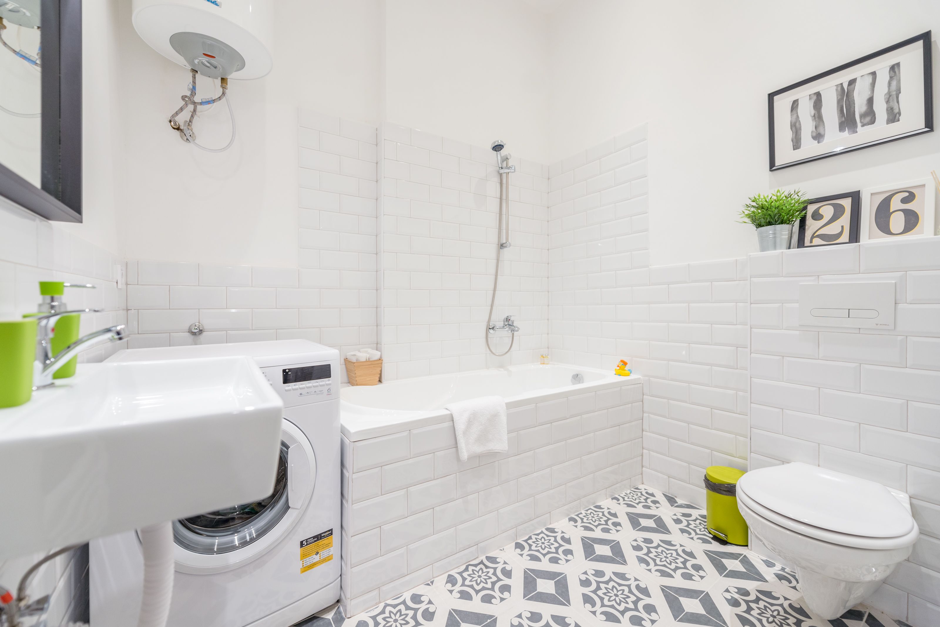 A bathroom with a white sink, a washing machine, a bathtub, and a toilet.