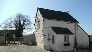 A white building with a black roof, a small porch, and a wooden gate. - LE JARRIER DETACHED HOLIDAY RENTAL - ALPES MANCELLES -PRIVATE  POOL -FIBER WIFI (Saint-Georges-le-Gaultier)