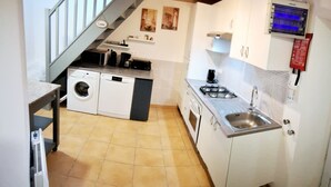 A compact kitchen with a washing machine, dishwasher, stove, and sink. - LE JARRIER DETACHED HOLIDAY RENTAL - ALPES MANCELLES -PRIVATE  POOL -FIBER WIFI (Saint-Georges-le-Gaultier)
