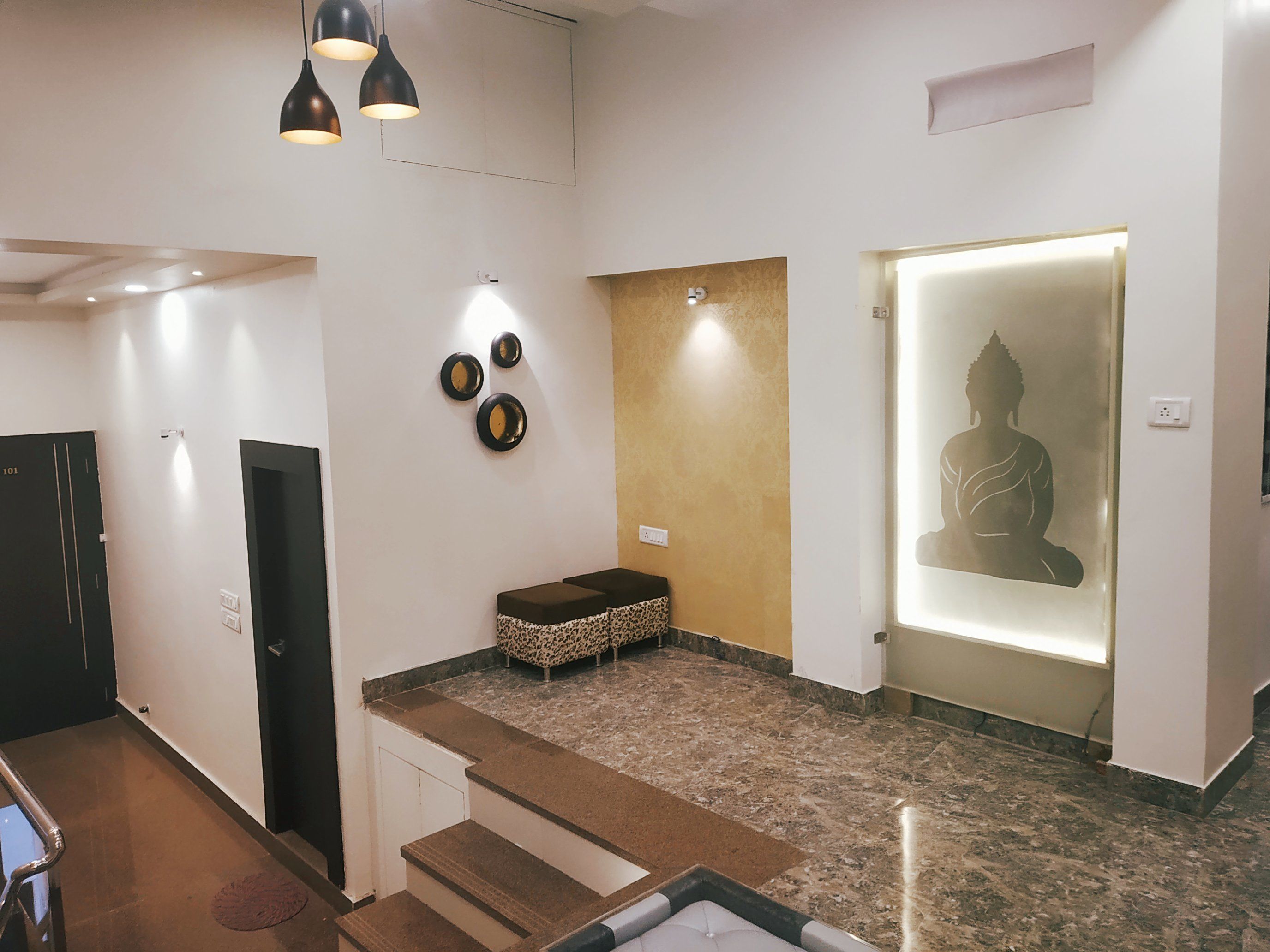 A modern interior with a reception area, a staircase, and a wall with decorative plates.