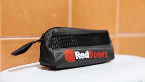 A black pencil case with the RedDoorz logo on a white surface against a tiled wall. - RedDoorz @ La Casa Guesthouse (Angeles City)