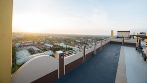 A rooftop terrace with a city view, railings, and a clear sky. - RedDoorz Premium @ Cityland Tagaytay 2 (Tagaytay)