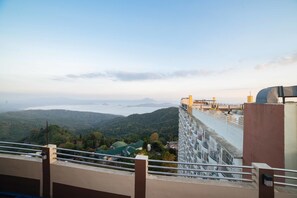 A high-rise building with a view of a valley and a body of water. - RedDoorz Premium @ Cityland Tagaytay 2 (Tagaytay)