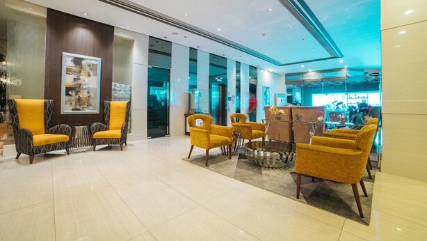 A lobby with modern furniture, a glass partition, and a reception area. - RedDoorz Premium @ West Avenue Quezon City (Quezon City)