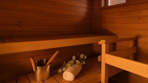 A wooden sauna with a bench, a metal bucket, a rolled towel, and a small window.