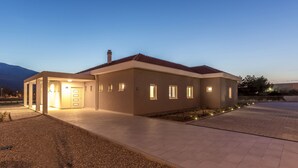 Una casa moderna con un amplio camino de entrada y una puerta principal bien iluminada.