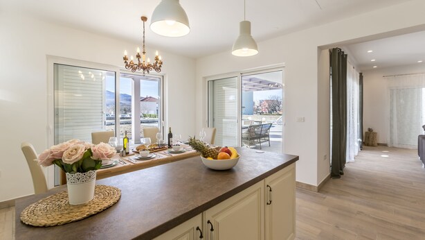 Una cocina moderna con mostrador de madera, un florero y un frutero.