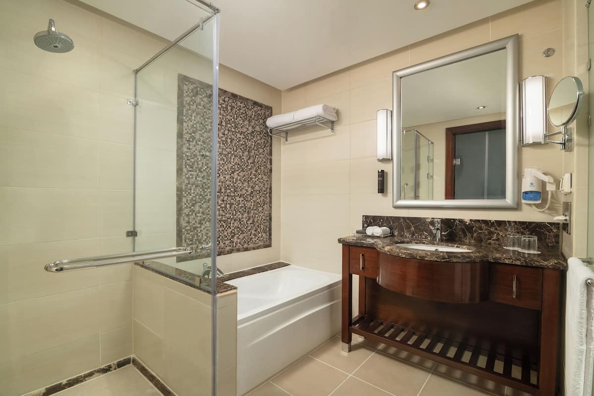 deluxe room, pool view | bathroom | combined shower/bathtub, free toiletries, hair dryer, slippers