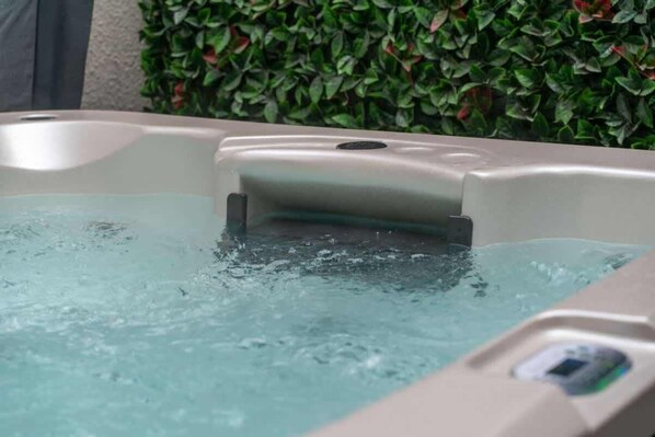 A hot tub with water, surrounded by a hedge. - Happy Daze Central Queenstown Hot Tub (Queenstown)