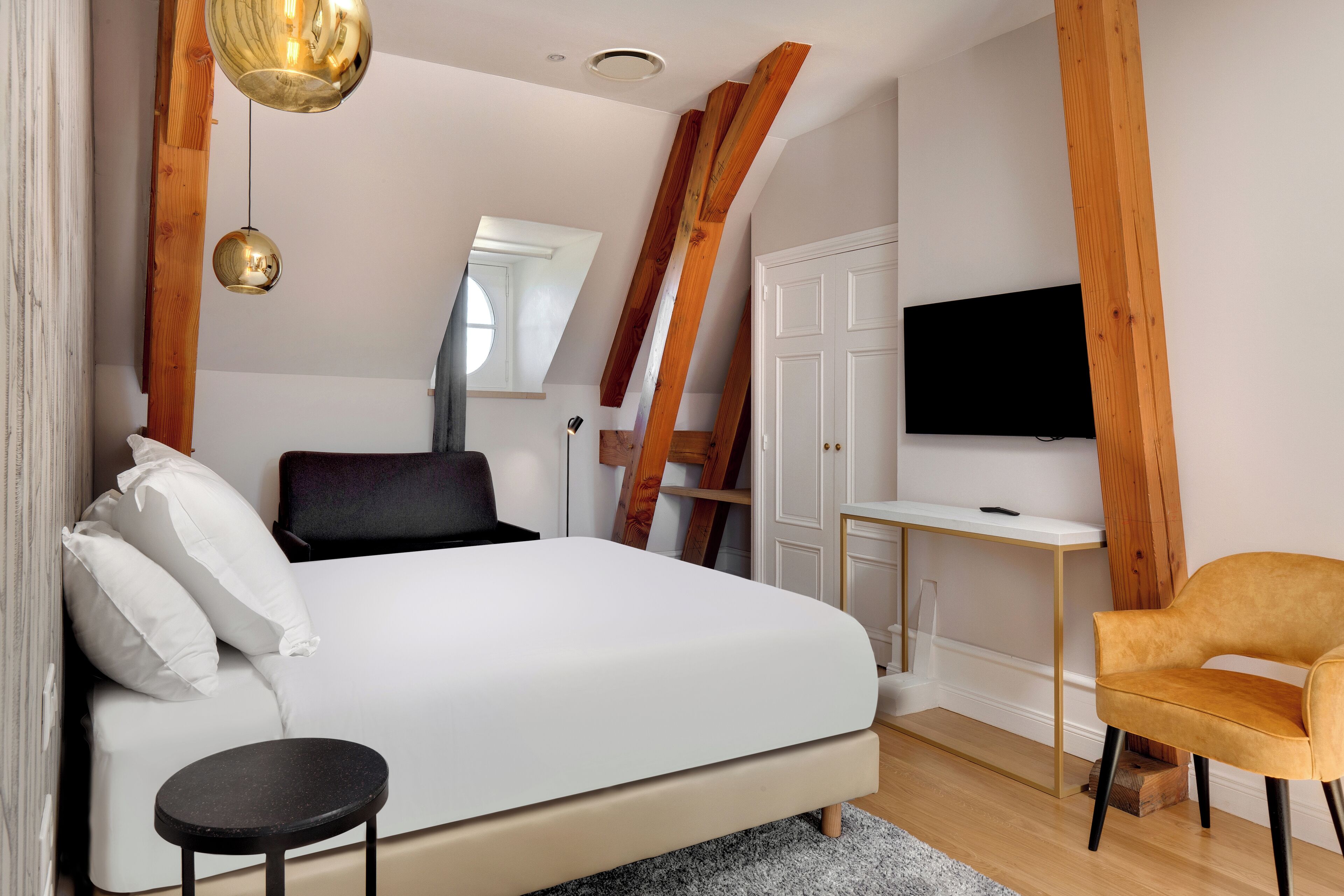 A bedroom with a bed, a desk, a chair, and a TV.