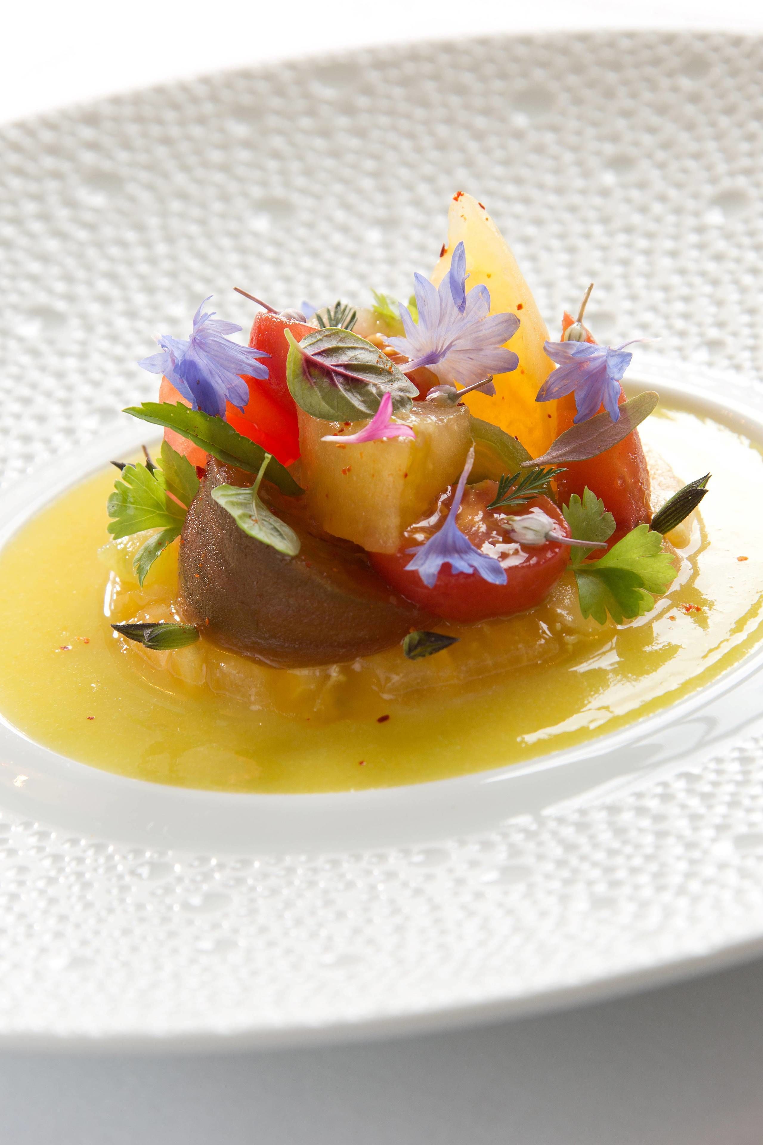 A plated dish with various vegetables and garnishes.
