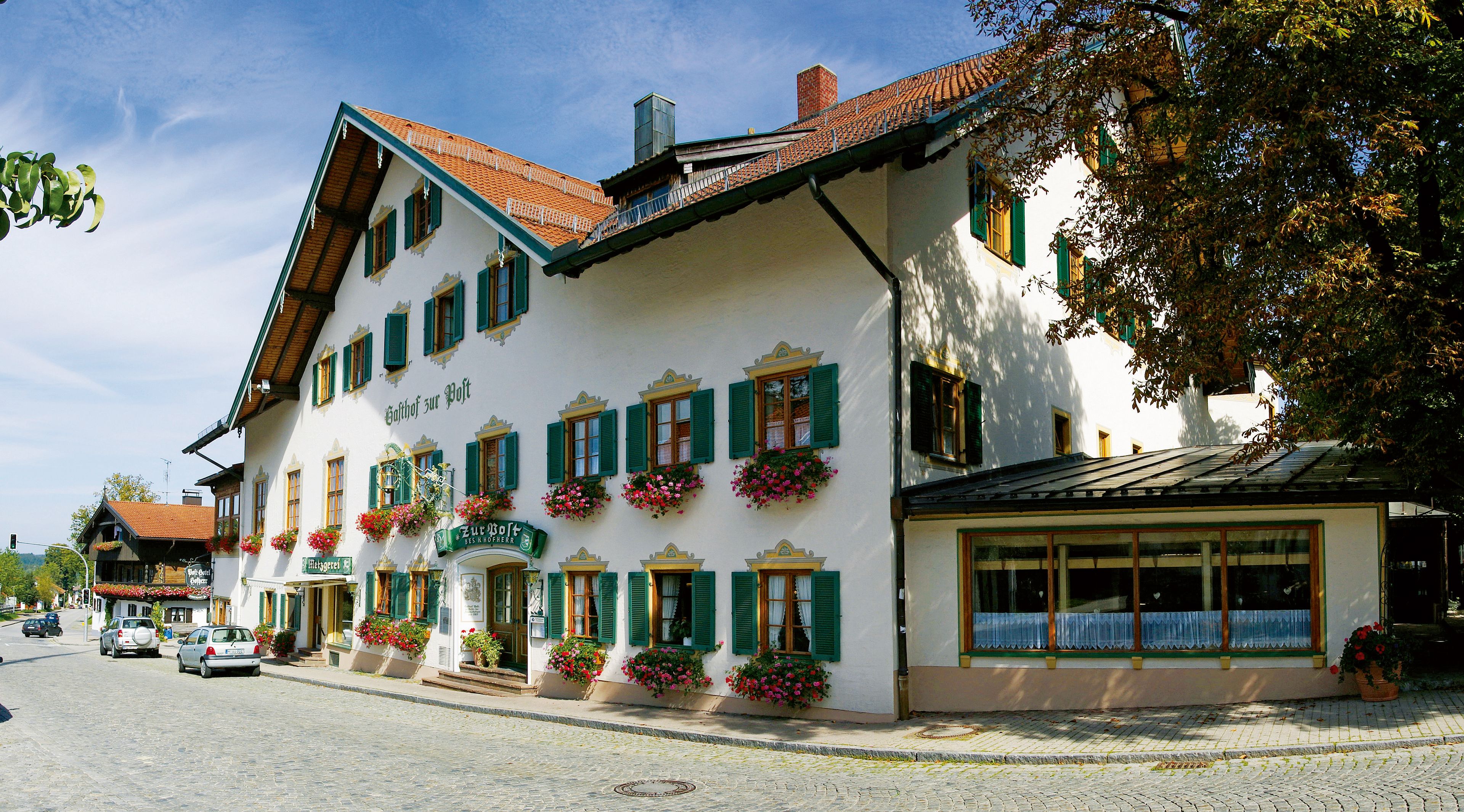 Ein traditionelles europäisches Gebäude mit zahlreichen Fenstern, einem Ziegeldach und Blumenkästen.