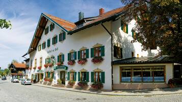 Ein traditionelles europäisches Gebäude mit zahlreichen Fenstern, einem Ziegeldach und Blumenkästen.