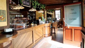 Eine Bar mit Holztresen, einer Kreidetafel und hängenden Pflanzen.