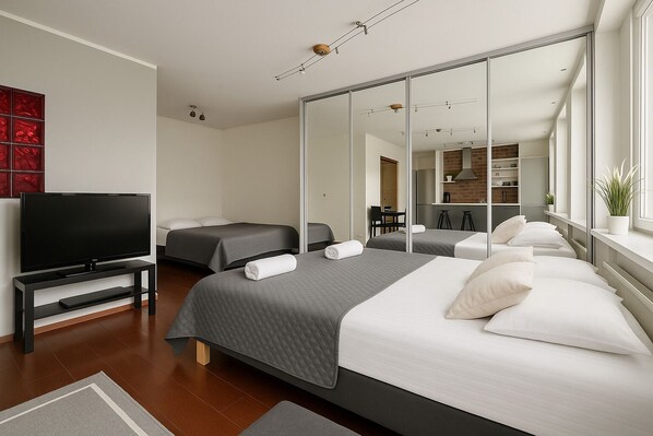 A modern hotel room with a large bed, a TV, a mirror, and a view of the kitchen. - City Home Finland Ratina (Tampere)