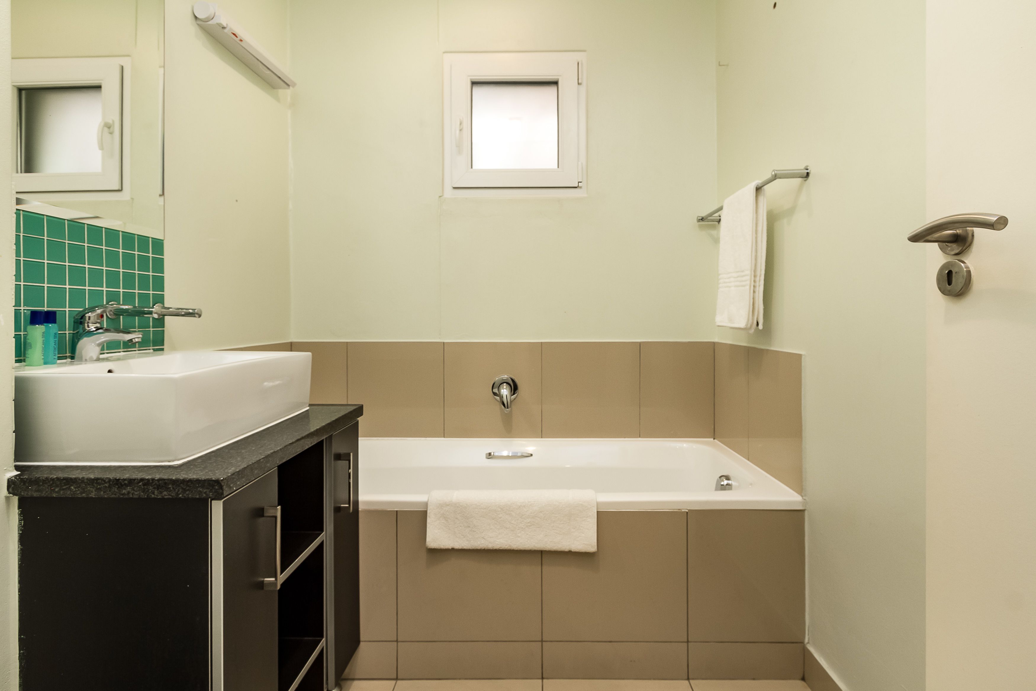 Ein Badezimmer mit Badewanne, Waschbecken und Spiegel.