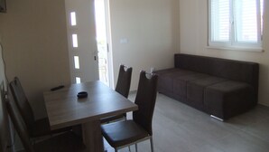 A dining area with a table, chairs, and a sofa. - Apartments Juliet (Orebic)