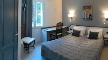 Een slaapkamer met een bed, een bureau en een stoel.