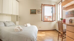 A bedroom with a bed, a desk, and a window. - Venezia - Castello 1542 (Venice)
