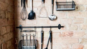 A kitchen with hanging utensils and a portable stove.