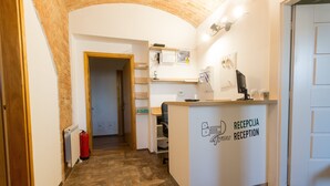 A reception area with a white reception desk, a computer, and a fire extinguisher.