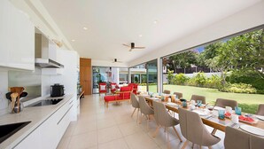 Eine moderne Küche mit Essbereich und Blick auf einen gepflegten Garten.