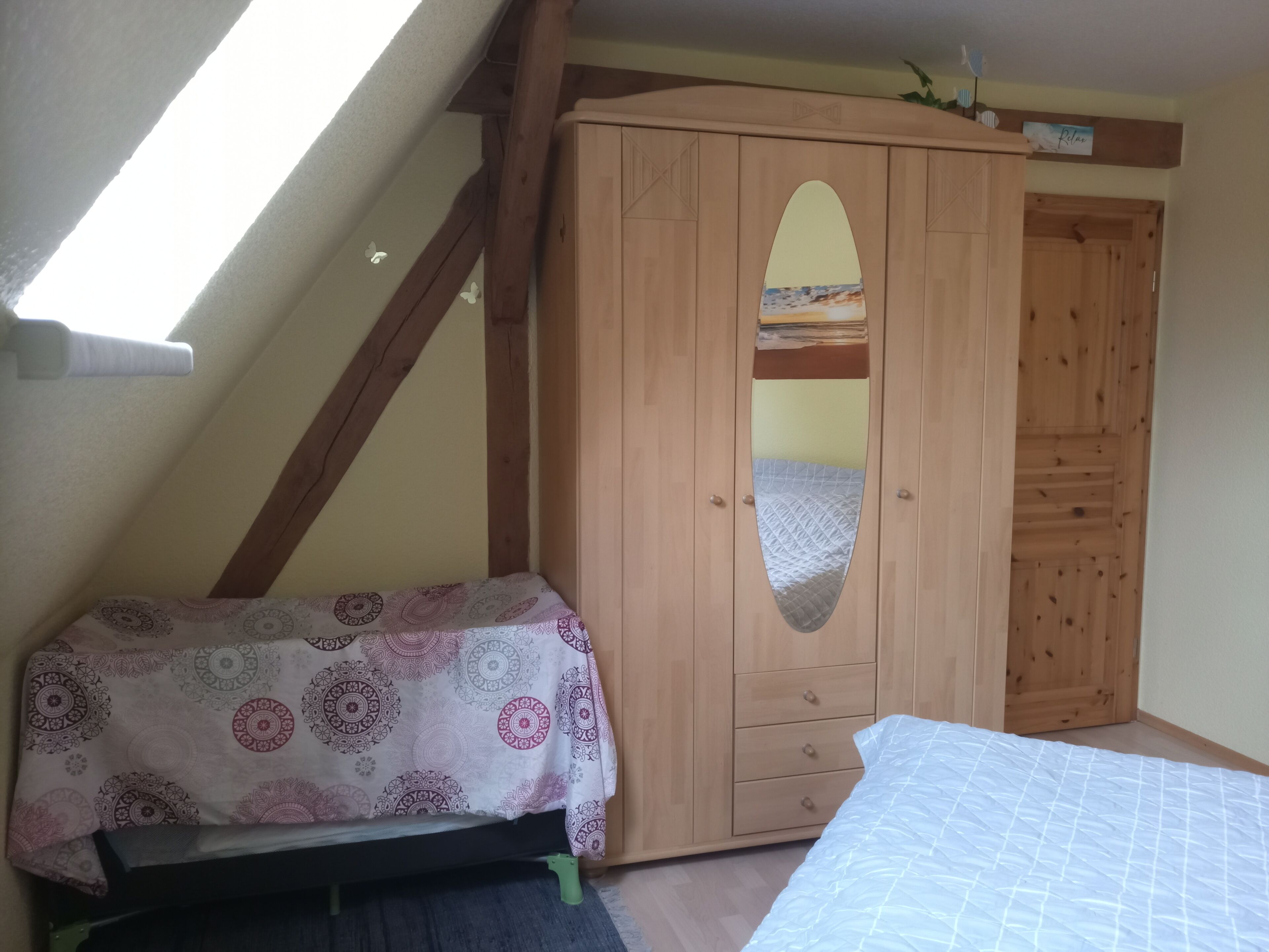 A bedroom with a bed, a wardrobe, and a skylight.