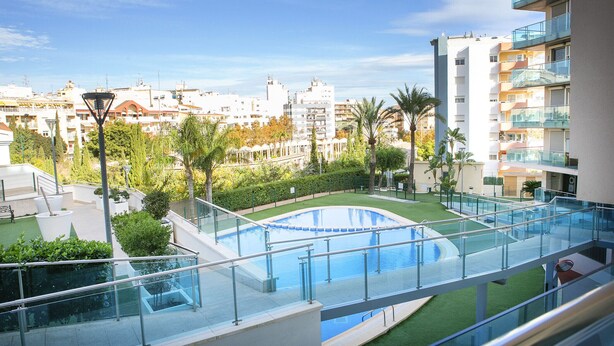 A residential building with a rooftop pool, green spaces, and a clear view of the cityscape. - Borumbot 8.0.3 Vista Piscina (Calpe)