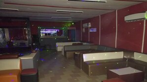 A restaurant with booths and tables, a bar area, and a checkered floor. - Residence Palace Hotel (Odienne)