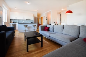 Relax in this stylish living space with a sofa, coffee table, and kitchen area.