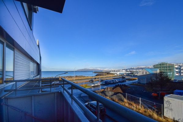 Enjoy breathtaking ocean views from this balcony overlooking the coast and surrounding mountains.