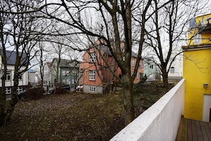 A residential area with houses, a tree-lined pathway, and a yellow building.
