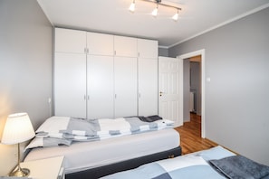 Cozy retreat with a large bed, wardrobe, and lamp.