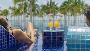 A poolside setting with two lounge chairs and a small table with drinks. - Barceló Maya Riviera - Adults Only - All Inclusive (Xpu-Ha)