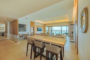 A modern interior with a dining area, seating, and a view of the sea. - Barceló Maya Riviera - Adults Only - All Inclusive (Xpu-Ha)
