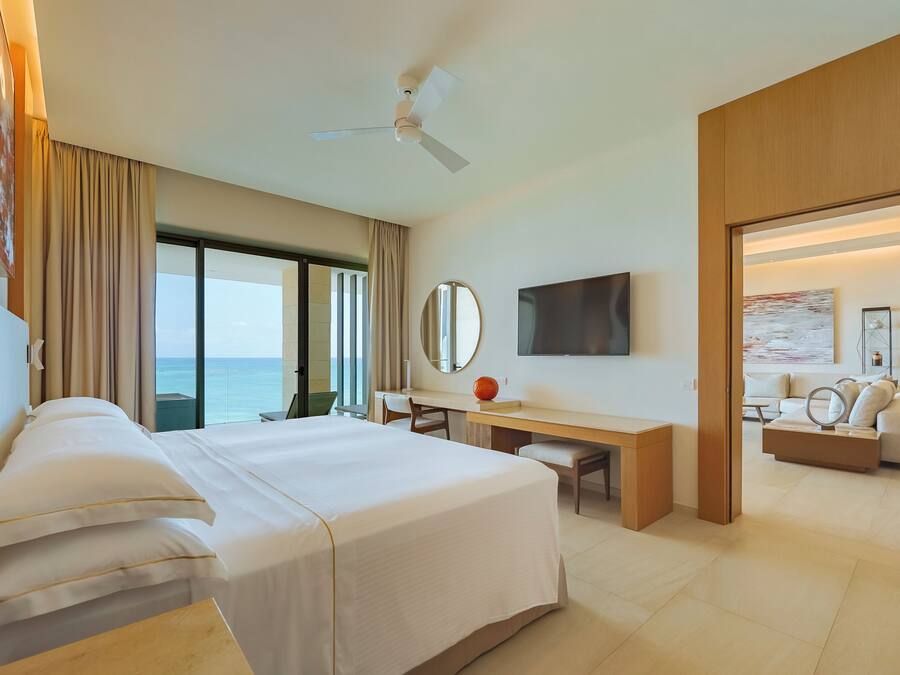 Ein Hotelzimmer mit Bett, Schreibtisch und Fernseher.