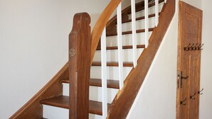A wooden staircase with white railings and a wooden door with hooks. - Holiday home Eifelträume for 6 people (Birresborn)