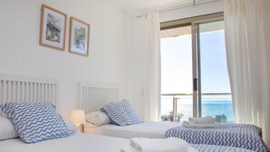 A hotel room with two beds, white bedding, and a view of the sea. - Borumbot 8.3.27 VistaMar (Calpe)