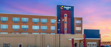 A Comfort Inn hotel with a modern brick facade, a prominent signage, and a parking lot with handicapped accessibility.