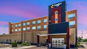 A Comfort Inn hotel with a modern design, featuring a prominent sign, a covered entrance, and a parking area. - Comfort Inn Portales (Portales)