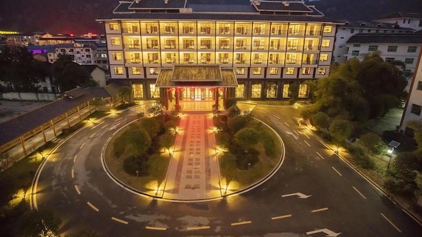 A multi-story hotel with a traditional architectural style, featuring a central courtyard with a red pathway. - Best Western Plus Qingxinyuan Hotel Zhangjiajie (Zhangjiajie)