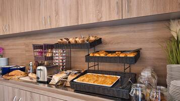 A buffet setup with various food items and utensils.