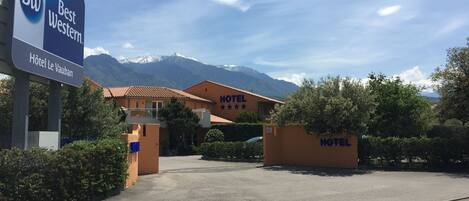 A hotel named 'Best Western Hôtel Le Vauban' with a mountain backdrop.