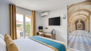 A hotel room with a large bed, a desk, a flat-screen TV, and a mural of a corridor. - Best Western Le Vauban (Prades)