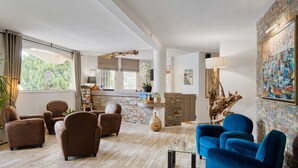 A spacious living area with a fireplace, a coffee table, and several sofas. - Best Western Le Vauban (Prades)