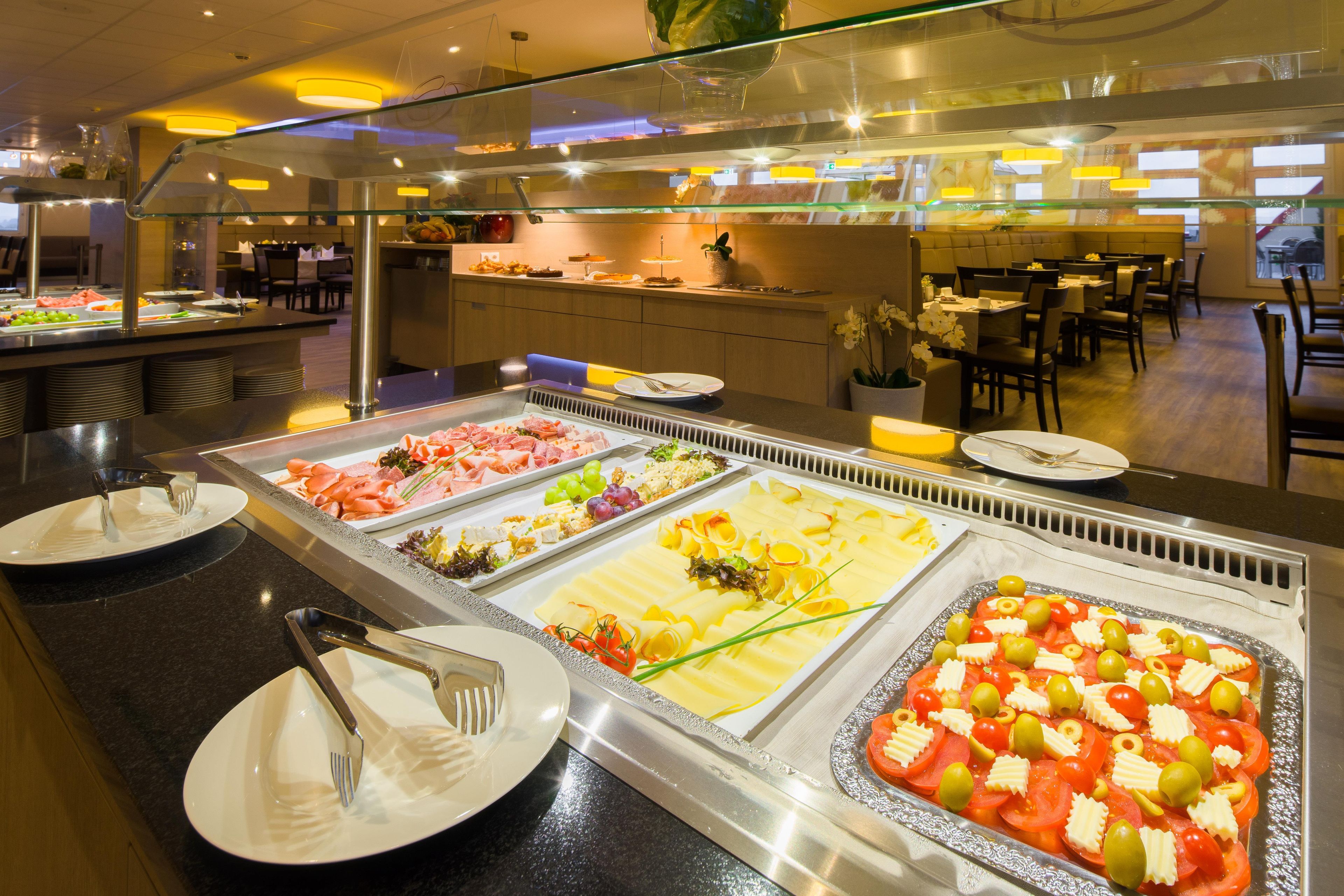 A buffet with various food options, including meats, cheeses, and salads.