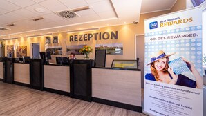 A reception area with a reception desk, a large sign advertising Best Western Rewards, and a view of the lobby. - Best Western Hotel Dreilaenderbruecke (Weil am Rhein)